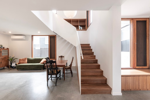 Interior open-plan living area with white walls, timber staircase and accents